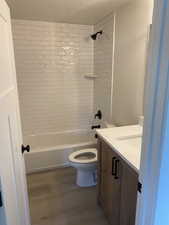 Full bathroom featuring wood finished floors, toilet, vanity, and shower / bath combination