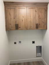 Laundry area featuring electric dryer hookup, cabinet space, baseboards, hookup for a washing machine, and wood finished floors