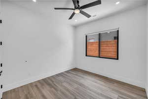 Spare room featuring wood finished floors, a ceiling fan, baseboards, and recessed lighting