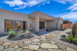Back of property featuring stucco siding and a patio