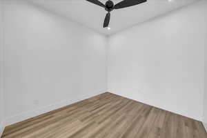 Unfurnished room with wood finished floors, a ceiling fan, recessed lighting, and baseboards