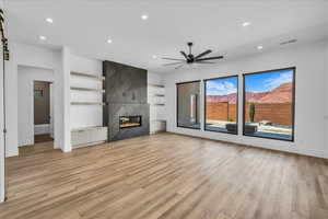 Unfurnished living room with light wood finished floors, baseboards, ceiling fan, and recessed lighting