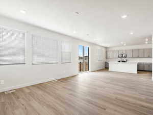 Unfurnished living room featuring light wood-style flooring, recessed lighting, and baseboards