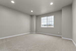 Spare room with recessed lighting, light carpet, and baseboards