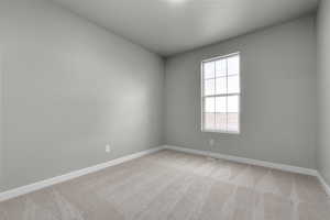 Empty room with baseboards and light carpet