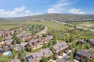 Aerial view of property and surrounding area with nearby suburban area and mountains