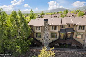 View of front facade featuring stairway, a shingled roof, a mountain view, and a residential view