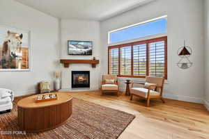 Living area with a fireplace, hardwood / wood-style floors, and baseboards