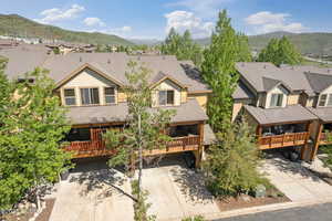 View of front of property with a mountain view, driveway, a residential view, and a shingled roof