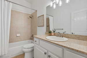 Full bath with vanity, shower / bath combination with curtain, toilet, and tile patterned floors