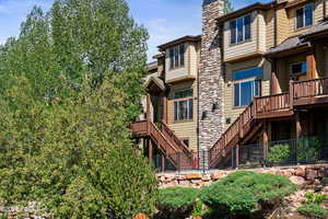 Rear view of house with stairway and a chimney