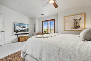 Carpeted bedroom with a ceiling fan, baseboards, and lofted ceiling