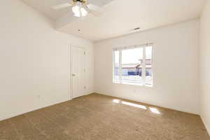 Carpeted guest  room with ceiling fan and baseboards