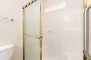 Full bathroom with a shower with shower door and toilet