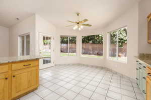 Kitchen with ceiling fan, light tile flooring, and light granite countertops