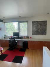 Office with light wood floors, built in study/office area, great natural light