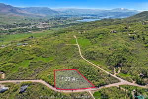 Aerial view of property and surrounding area with a water and mountain view and property parcel outlined
