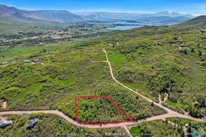 Aerial view of property's location featuring a water and mountain view and property parcel outlined