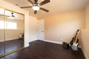 Empty room with ceiling fan, wood finished floors, and baseboards