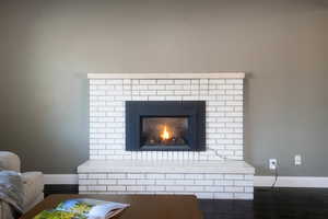 Detailed view of baseboards, wood finished floors, and a fireplace