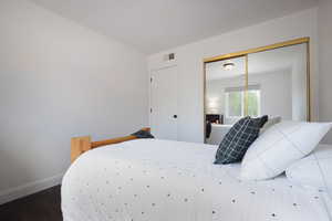 Bedroom featuring wood finished floors, baseboards, and a closet