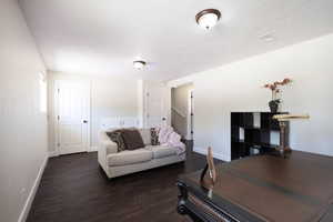 Living room with dark wood-style floors and baseboards