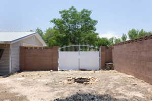 View of yard featuring a gate and a fire pit