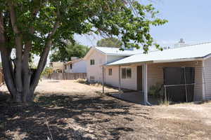Rear view of house with a patio, metal roof, and a chimney