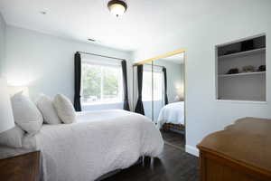 Bedroom featuring dark wood-style flooring, a closet, and baseboards