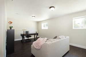 Living room featuring dark wood finished floors and baseboards