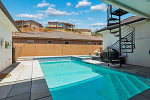 View of pool with a fenced backyard, grilling area, a pool with connected hot tub, and a patio