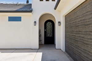 Doorway to property featuring stucco siding