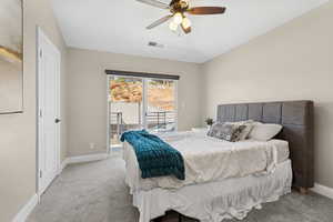 Bedroom with access to exterior, light carpet, baseboards, and a ceiling fan