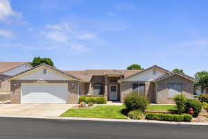 Ranch-style house with a tile roof, a garage, concrete driveway, and a front yard