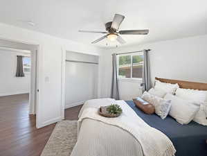 Bedroom with a closet, dark wood-style floors, ceiling fan, and baseboards
