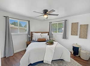 Bedroom with multiple windows, wood finished floors, and baseboards