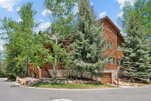 View of front of property featuring a garage, stairs, and stone siding