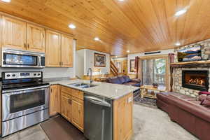 Kitchen featuring appliances with stainless steel finishes, light stone countertops, wood ceiling, light brown cabinetry, and recessed lighting