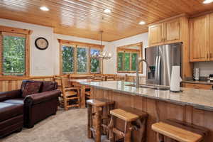 Kitchen with stainless steel fridge, wooden ceiling, recessed lighting, plenty of natural light, and a kitchen bar