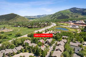 Aerial view of property and surrounding area with nearby suburban area and a water and mountain view