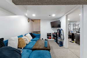 Carpeted living area with baseboards and recessed lighting