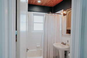 Bathroom featuring shower / bath combo with shower curtain, wood ceiling, and recessed lighting
