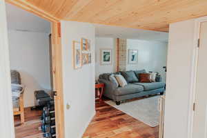 Living area featuring wood ceiling, light wood-style floors, and baseboards