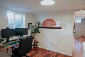 Office featuring wood finished floors, plenty of natural light, and baseboards