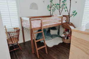 Bedroom with wood finished floors and multiple windows