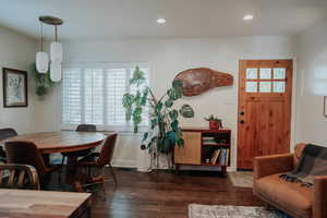 Dining space with dark wood finished floors and recessed lighting