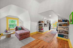 Living area featuring vaulted ceiling, wood finished floors, and baseboards