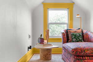 Sitting room featuring vaulted ceiling and baseboards