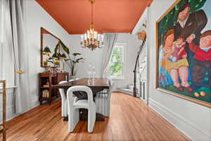 Dining space with a chandelier, crown molding, light wood finished floors, and baseboards