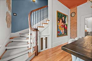 Stairway featuring wood finished floors, crown molding, and baseboards